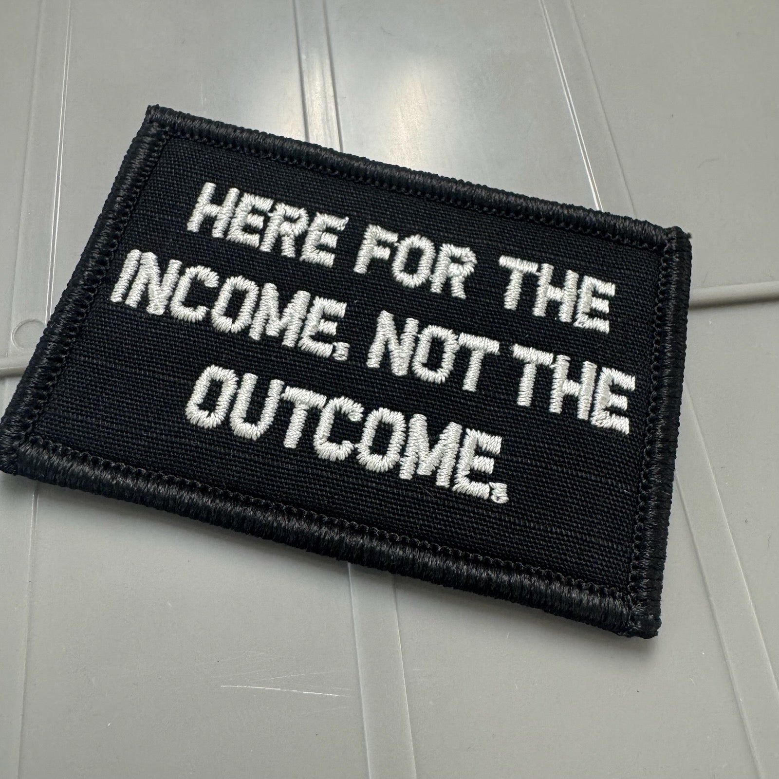 As Seen on Socials - Here For The Income, Not The Outcome. - 2x3 Patch - Black w/Silver